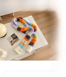 Close-up of a colorful rainbow striped chunky knit scarf with a woven textile label