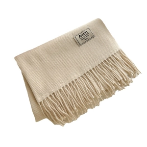 Écharpe beige en cachemire synthétique avec franges et étiquette logo sur fond blanc