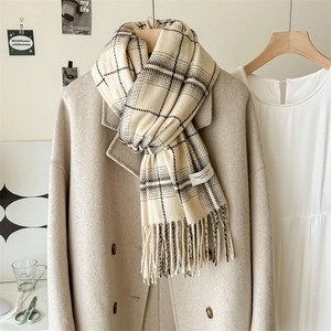 Plaid cashmere-like scarf with tassels in beige and black over a wool coat