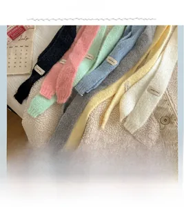 Dettaglio di morbide sciarpe colorate in maglia con etichette in tessuto minimaliste