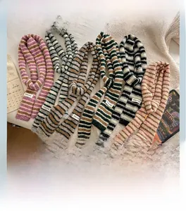 Detail of colorful striped knitted scarves with fringe texture and branded label