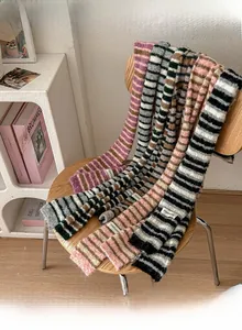 Detail of striped knitted scarves in various colors draped over a wooden chair