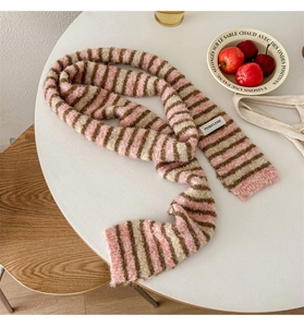 Close-up of pink and brown striped knit scarf with branded label on a white tabletop