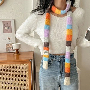 Rainbow striped knit scarf with long colorful fuzzy pattern for women in a cozy winter setting
