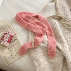Elegante sciarpa in maglia rosa abbinata a un gilet beige in pelliccia sintetica stile rustico