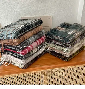 Dettaglio di sciarpe scozzesi multicolore con frange morbide e trama a maglia spessa