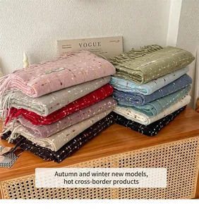 Detail van dikke gebreide sjaals met gespikkelde textuur en franjes in vele kleuren