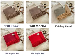 Detail view of thick wool blend scarves in khaki, mocha, and red with elegant tassels