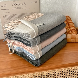 Elegant wool blend scarf in multi-color options with tassels on a wooden table