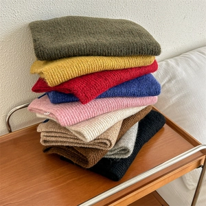 Pila di sciarpe di lana lavorate a maglia in vari colori vivaci per l'inverno