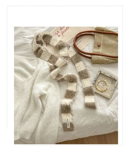 Détail de l'écharpe en maille rayée à texture duveteuse et étiquette de marque