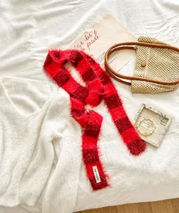Gros plan détaillé de l'écharpe en peluche à damier rouge et noir avec label de marque