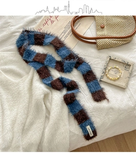 Détail de l'écharpe en peluche à damier bleu et marron avec texture douce et étiquette
