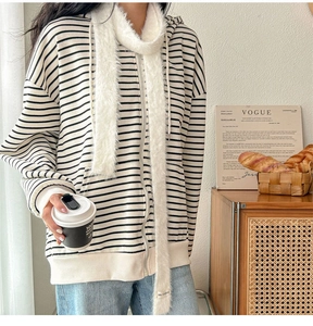 Soft white faux fur long scarf styled with a striped zip-up hoodie in a cozy scene