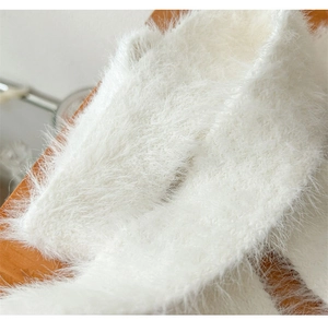 Close-up of soft white plush faux fur scarf showing fluffy texture and premium material