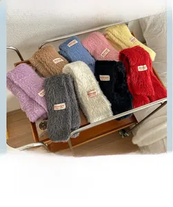 Dettaglio di sciarpe in maglia soffice in vari colori esposte in un carrello metallico