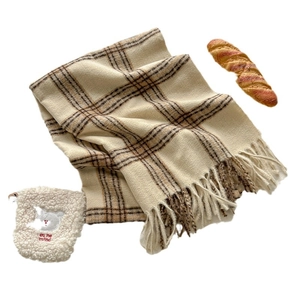 Geruite sjaal met franjes, beer opbergtas en decoratieve baguette op witte achtergrond