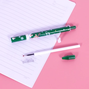 Green Christmas retractable gel pen with snowman pattern and internal components on notebook