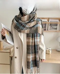 Detail of thick plaid knit scarf in brown and blue with long fringe tassels