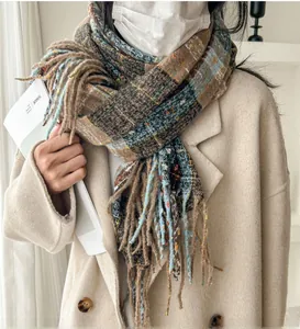 Detail of vintage plaid scarf with long tassels paired with a beige wool coat
