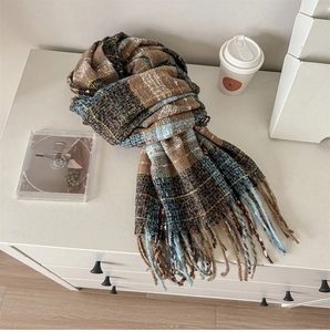 Close-up of thick plaid scarf with fringe, featuring brown and blue vintage check pattern