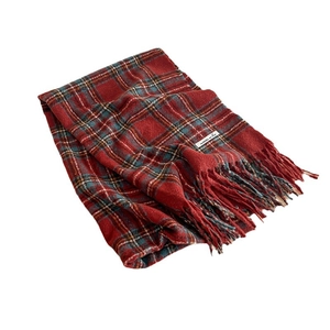 Red plaid Christmas scarf with green stripes and tassels on a clean white background