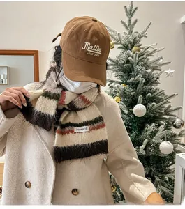 Close-up of knit wool striped scarf paired with a brown Malibu embroidery baseball cap