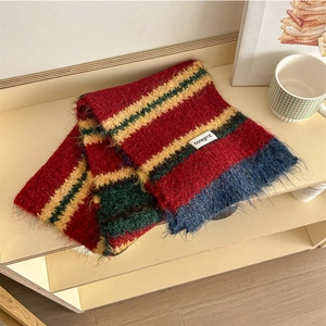 Detail of color-block knitted scarf with soft fringes and authentic brand woven label
