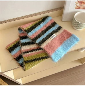 Close-up of colorful striped knit wool scarf showing soft mohair texture and logo label