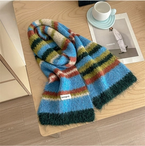 Detailed close-up of fluffy colorful striped knit wool scarf with premium woven label