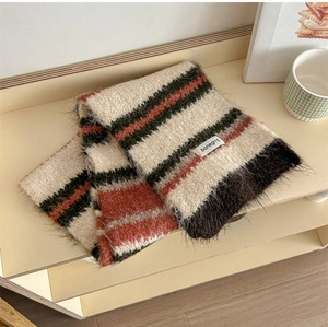 Close-up of color-block knit wool scarf texture with brand label and stripe pattern
