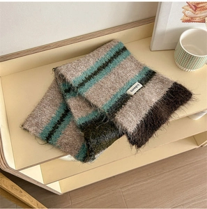 Detailed close-up of striped wool knit scarf with brand label on a wooden shelf