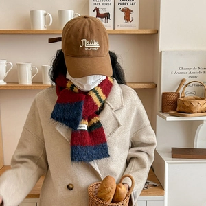 Winter striped knit scarf with brown Malibu baseball cap and beige wool coat for women