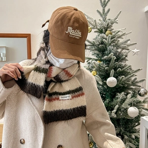Winter striped knit scarf with Malibu baseball cap set in cozy festive holiday scene