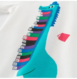 Detail of creative blue dinosaur print with colorful stacked books on white cotton T-shirt