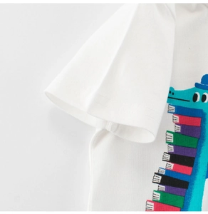 Close-up of a white cotton t-shirt featuring a colorful cartoon dinosaur with rainbow scales