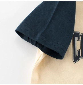 Gros plan sur les coutures des manches raglan et la texture du t-shirt en coton pour enfant
