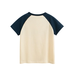 Détail d'un t-shirt raglan enfant avec manches bleu marine et tissu en coton jaune doux