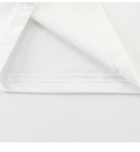 Vue macro des coutures à double aiguille sur l'ourlet du t-shirt blanc