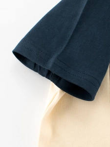 Détail de la manche d'un t-shirt bleu marine et crème avec couture double précise