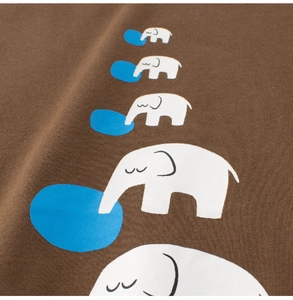 Close-up of elephant prints and cotton fabric texture on a dark brown kids' T-shirt