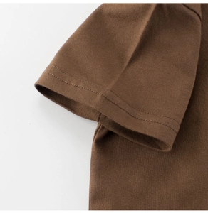 Detail of double-needle stitching on the cuff of a brown cotton t-shirt for boys