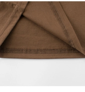 Close-up of double-needle stitching on dark brown cotton fabric for kids T-shirt