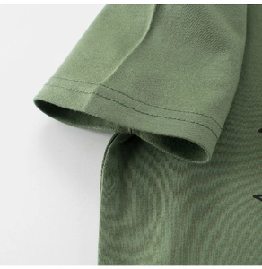 Detailed close-up of double-stitched sleeve cuff on green cotton kids t-shirt