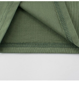 Macro detail of high-quality double-needle hem stitching on green cotton kids' T-shirt