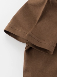 Detail view of cotton t-shirt sleeve cuff with durable double stitching in dark brown