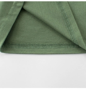Détail du t-shirt en coton vert Morandi montrant une couture professionnelle à double aiguille