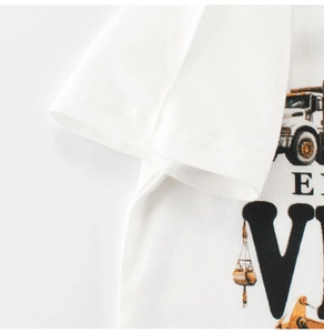 Détail du tissu en coton et de l'imprimé camion sur un t-shirt blanc pour enfants