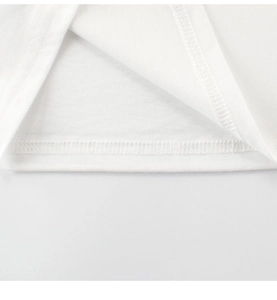 Vue détaillée des coutures surjetées et du tissu en coton d'un t-shirt blanc pour enfants