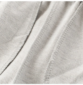 Detailed macro view of light gray twill fabric and double-needle stitching on kids shorts